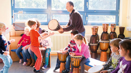 Schüler der Achenbach Schule Herford trommeln mit ihrem Lehrer im Klassenzimmer.