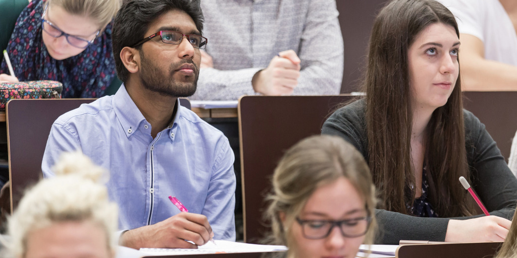 Studenten der Uni Wien sitzen in einem Hörsaal und lauschen einer Vorlesung. 