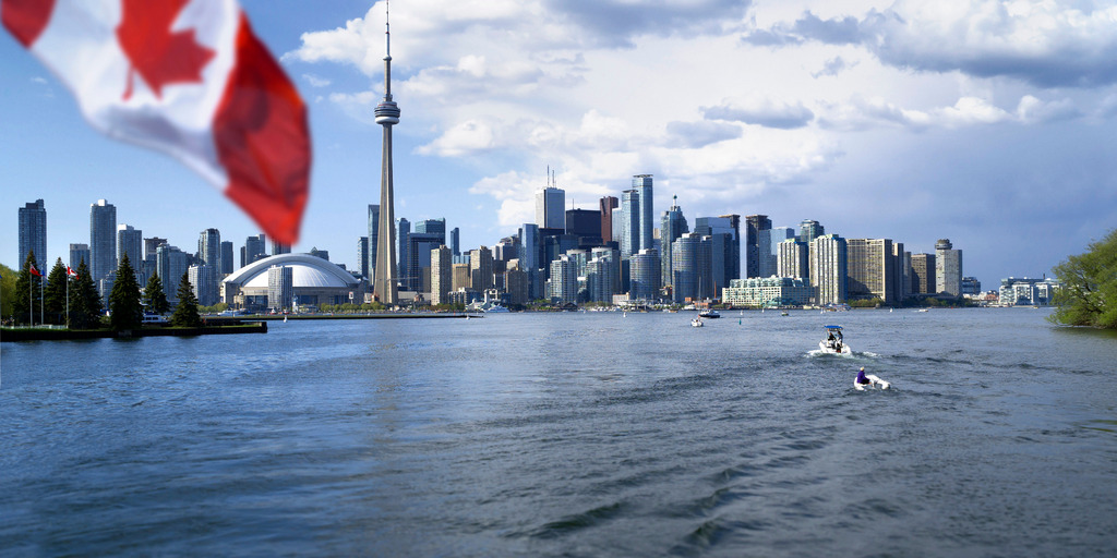 Man die Skyline von Toronto vom Wasser aus. Im Vordergrund die Flagge von Kanada