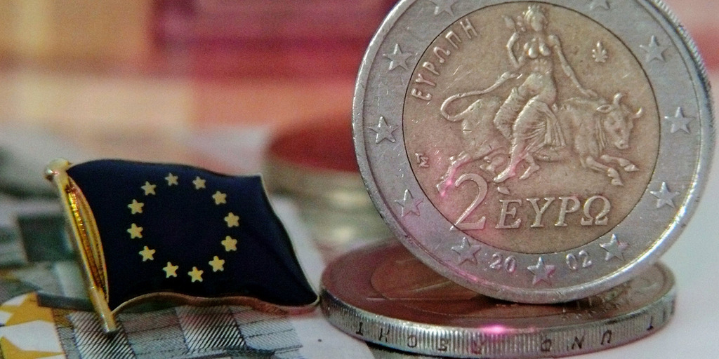 2 EURO Münze mit griechischem Motiv, daneben eine Europaflagge