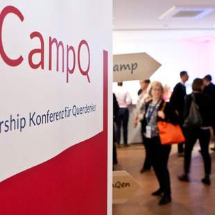 Im Vordergrund: das Camp Q-Banner | im Hintergrund: Personen