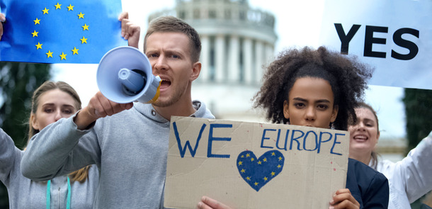 Junge Demonstranten mit Megaphon und Love Europe-Schild.