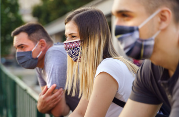 Gruppe junger Menschen mit Mund- und Nasenschutz in Nahaufnahme