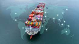 Mit Containern beladenes Frachtschiff fährt auf ruhigem Wasser, darunter zu sehen eine Weltkarte mit Handelspunkten