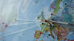 Europakarte mit Pins, verbunden mit Bindfäden