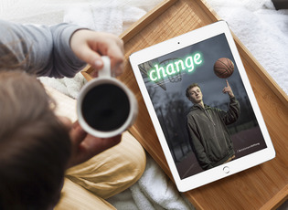 Vor einer Person, die eine Kaffeetasse in der Hand hält, liegt ein Tablet, auf dem das Titelbild des aktuellen change Magazins zu sehen ist.