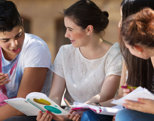 Schüler:innen lernen gemeinsam, draußen auf dem Schulhof.