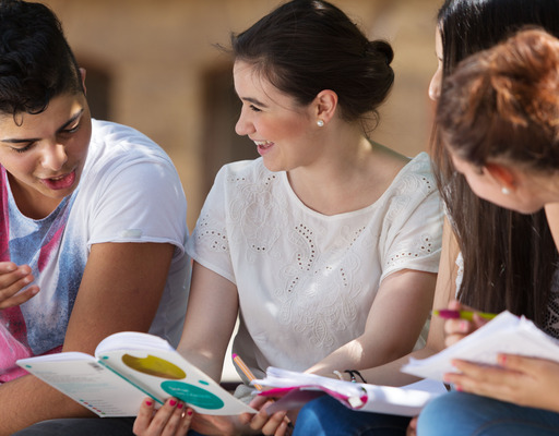 Schüler:innen lernen gemeinsam, draußen auf dem Schulhof.