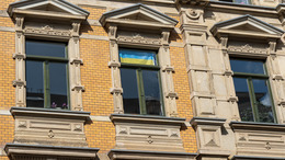 großes Wohnhaus Altbau mit Ukrianeflagge im Fenster in Leipzig