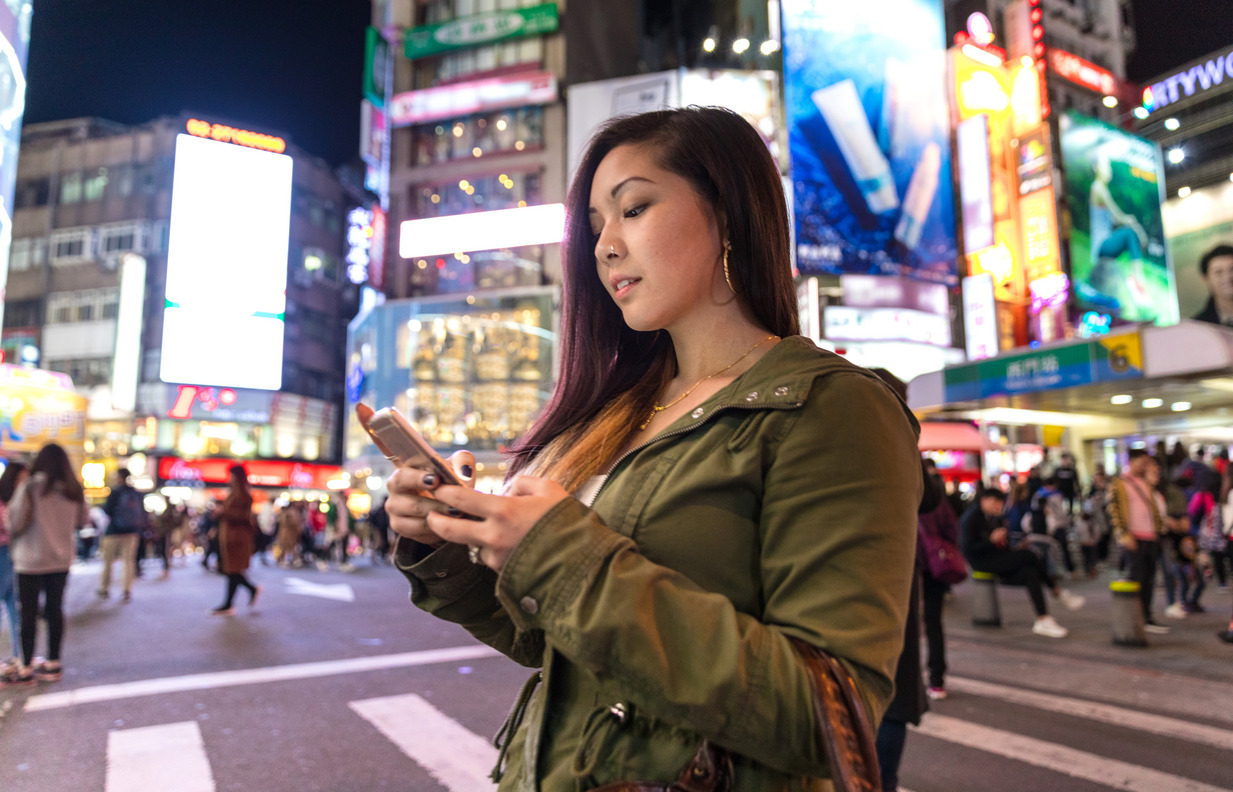 Asiatische Frau nachts in der Großstadt