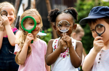 4 kinder mit jeweils einer Lupe in der Hand