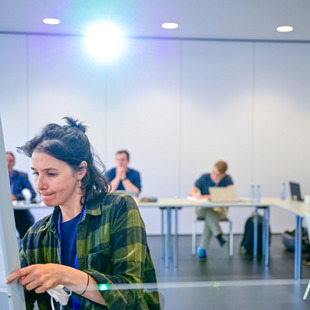 Teilnehmerin notiert Inhalte am Flipchart.