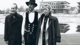Reinhard Mohn steht mit seiner Frau Liz Mohn und dem Zimmermann Wilhelm Boeger vor dem Neubau des Stiftungsgebäudes