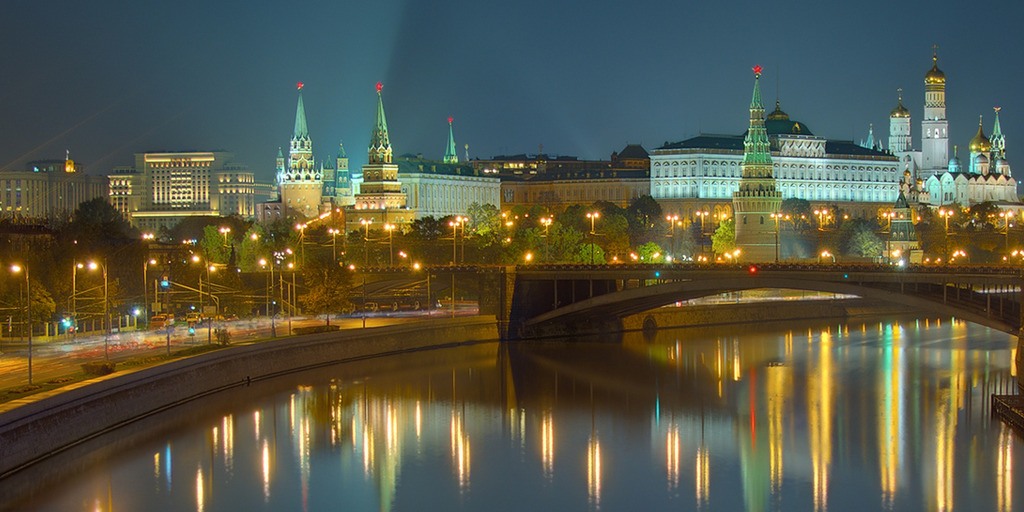 The Kremlin, the Moskva river with the Greater Stone Bridge and the State Duma building in Moscow at night.