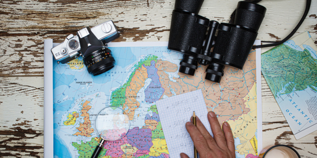 Europakarte mit Lupe und Fernglas darauf