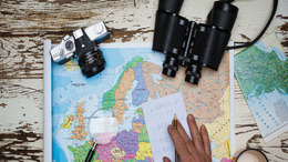 Europakarte mit Lupe und Fernglas darauf