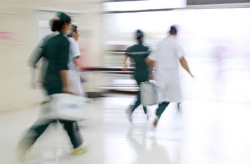 Mitarbeiter des Gesundheitswesens eilen an der Notbehandlungshalle vorbei.