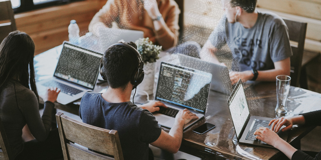 Menschen arbeiten mit Laptops zusammen an einem Tisch