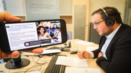 Trainer vor dem Bildschirm, Umfrage und eine Teilnehmerin auf dem Bildschirm zu sehen