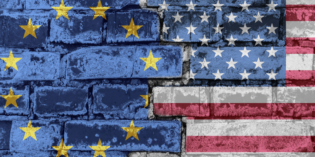 Die Flagge der Europäischen Union und Amerikas auf einer Backsteinmauer.