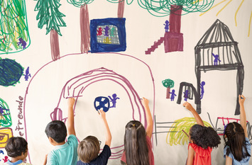 Schulkinder malen ein Bild an einer Tafel