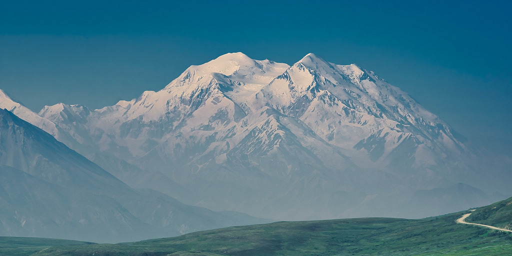 Mountain range with green meadow.