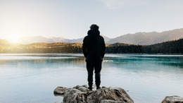 Mann stehend am stillen See