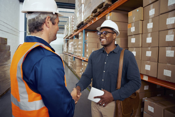 African worker shaking hand with his partner wearing safety helmet holding tablet in hand(© © StratfordProductions - stock.adobe.com)