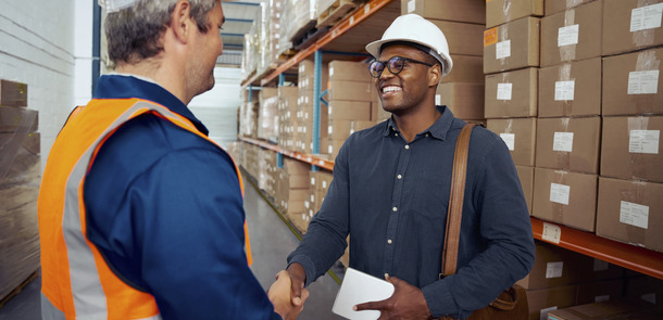 African worker shaking hand with his partner wearing safety helmet holding tablet in hand(© © StratfordProductions - stock.adobe.com)