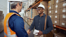 African worker shaking hand with his partner wearing safety helmet holding tablet in hand(© © StratfordProductions - stock.adobe.com)