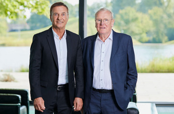 Bodo Uebber und Werner Bauer posieren im Foyer der Bertelsmann Stiftung in Gütersloh für ein gemeinsames Foto.