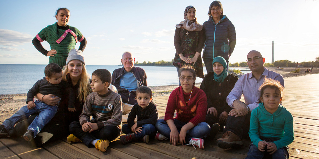 Der Syrische Flüchtling Mohamed Nouman sitzt mit seiner Familie und seinen beiden Sponsoren an der Uferpromenade von Toronto