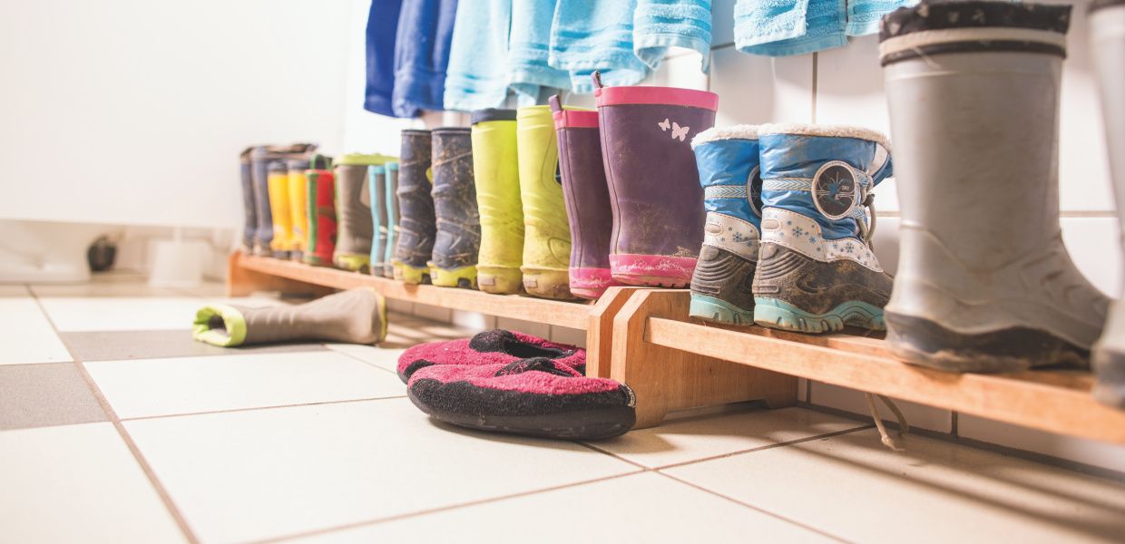 (© Jan Voth) In einer Kindertagesstätte stehen mehrere Paare Kinder-Gummistiefel nebeneinander aufgereiht.