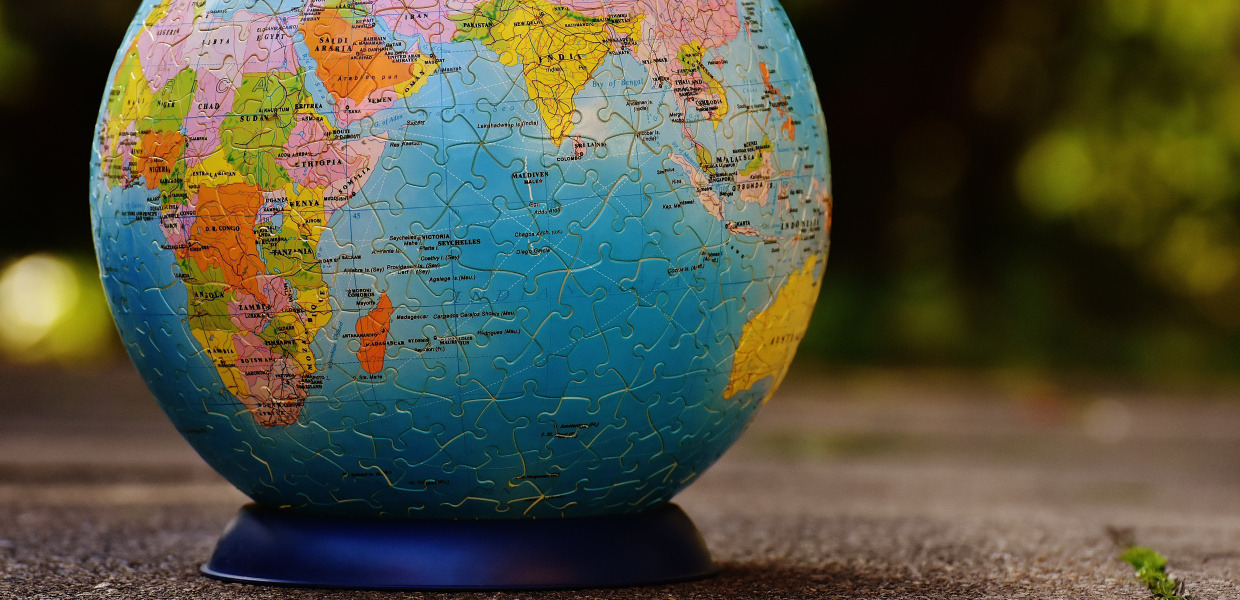 (© Alexas_Fotos / Pixabay - CC0, Public Domain) A globe consisting of puzzle pieces stands on a terrace, in the background evening darkness can be seen.