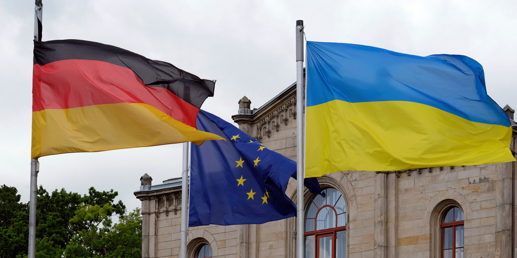 Vor einem Gebäude wehen die Flaggen von Deutschland, Europa und der Ukraine