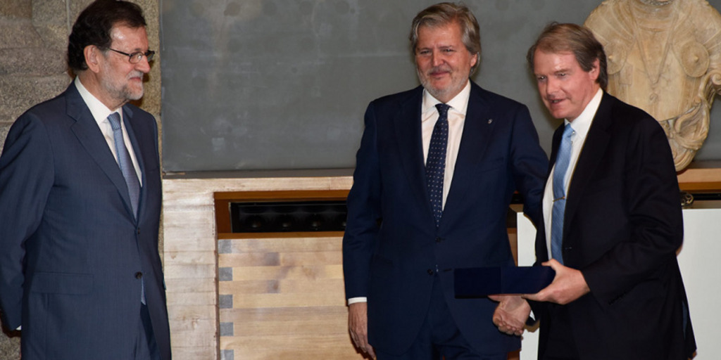 Francisco Belil hält den Orden für Liz Mohn in einer Schatulle in seinen Händen, neben ihm stehen Spaniens Ministerpräsident Mariano Rajoy und Kulturminister Iñigo Méndez de Vigo.