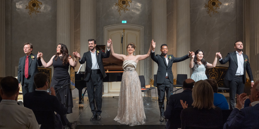 Die Künstler:innen nehmen am Ende des Preisträgerkonzerts ihren Applaus entgegen. Zu sehen sind Pianist Manuel Lange, und die Sänger:innen Marvic Monreal, Carles Pachon, Francesca Pia Vitale, Sakhiwe Mkosana, Yewon Han und Dumitru Mitu.