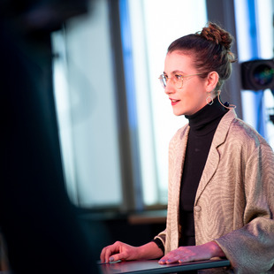 Deborah Düring, Bundestagsabgeordnete der Grünen, hat ihre Hände auf ihr Pult gelegt und spricht.