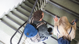 Zwei Schüler:innen gehen die Treppe hoch.