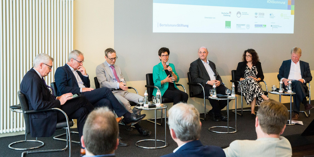 Podiumsdiskussion: folgendes Personen sitzen auf einem erhöhten Podium (von rechts nach links). Reiner Hoffmann, Sarah Ryglewski, Uwe Zimmermann, Dr. Kirsten Witte, Dr. Kay Ruge, Helmut Dedy, Patrick H. Leusch.