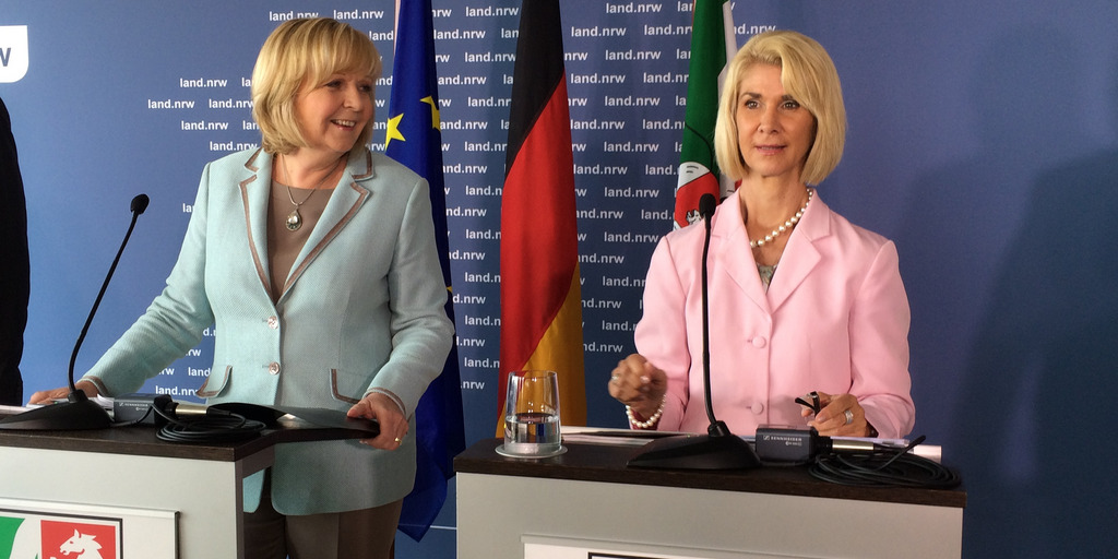 Brigitte Mohn und Hannelore Kraft stehen hinter Rednerpulten auf der Pressekonferenz zum Abschlussbericht Kein Kind zurücklassen. KOmmunen in NRW beigen vor.