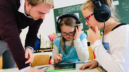 Schüler und Lehrer arbeitet zusammen an einem tablet