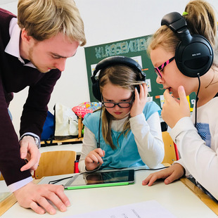 Schüler und Lehrer arbeiten mit digitalen Medien