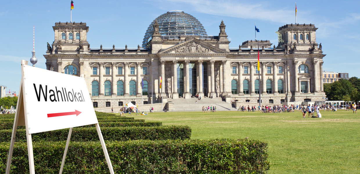 (© pitsch22 - stock.adobe.com) In front of the Reichstag building in Berlin there is a sign pointing to a polling station.