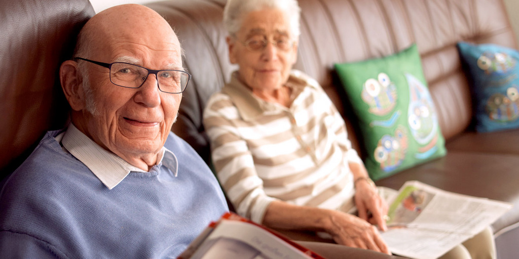 Ein älteres Pärchen sitzt auf der Couch und liest Zeitschriften