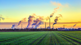 [Translate to English:] Qualmende Industrie vor grünem Feld
