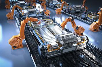 Das Bild zeigt eine hochautomatisierte Produktionsstraße in einer Fabrik, auf der Roboterarme Komponenten für Elektrofahrzeuge montieren