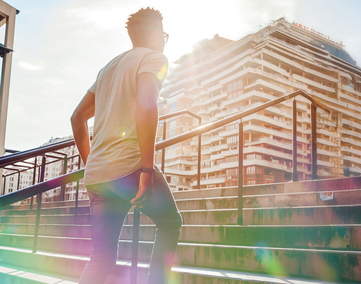 Junger Mann geht in der Stadt eine Treppe hoch