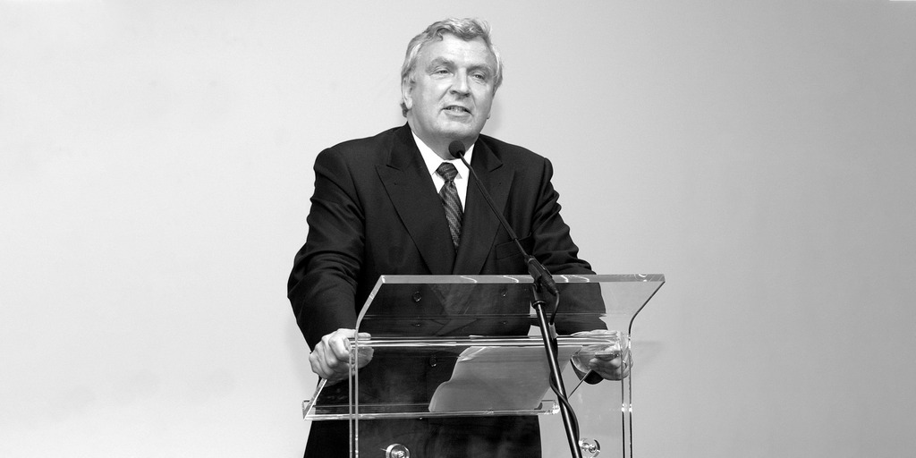 Foto von einer Rede von Gerd Schulte-Hillen, der hinter einem Rednerpult steht.