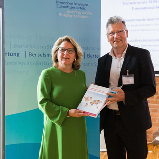 Ulrich Kober von der Bertelsmann Stiftung übergibt die Abschlusspublikation „Fachkräftemigration fair gestalten durch transnationale Skills Partnerships“ an die Bundesministerin für wirtschaftliche Zusammenarbeit und Entwicklung Svenja Schulze